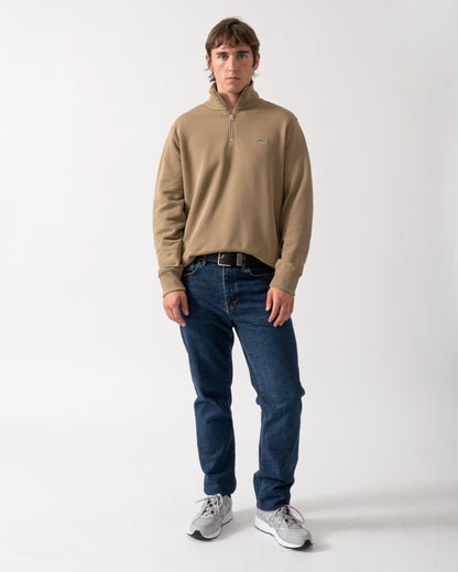 full length shot of a model wearing a GANT Mens Regular Fit Shield Logo Half Zip Sweatshirt in 264 Light Taupe