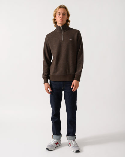 full length of a model wearing a GANT Mens Regular Fit Shield Logo Half Zip Sweatshirt in 284 Black Brown Melange