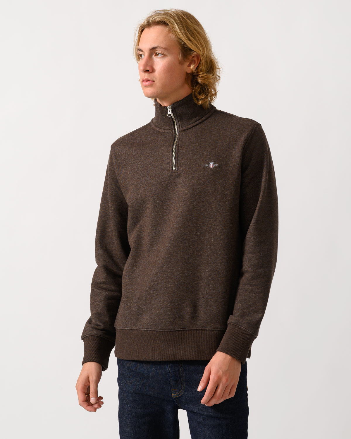 model wearing a GANT Mens Regular Fit Shield Logo Half Zip Sweatshirt in 284 Black Brown Melange