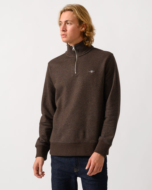 model wearing a GANT Mens Regular Fit Shield Logo Half Zip Sweatshirt in 284 Black Brown Melange