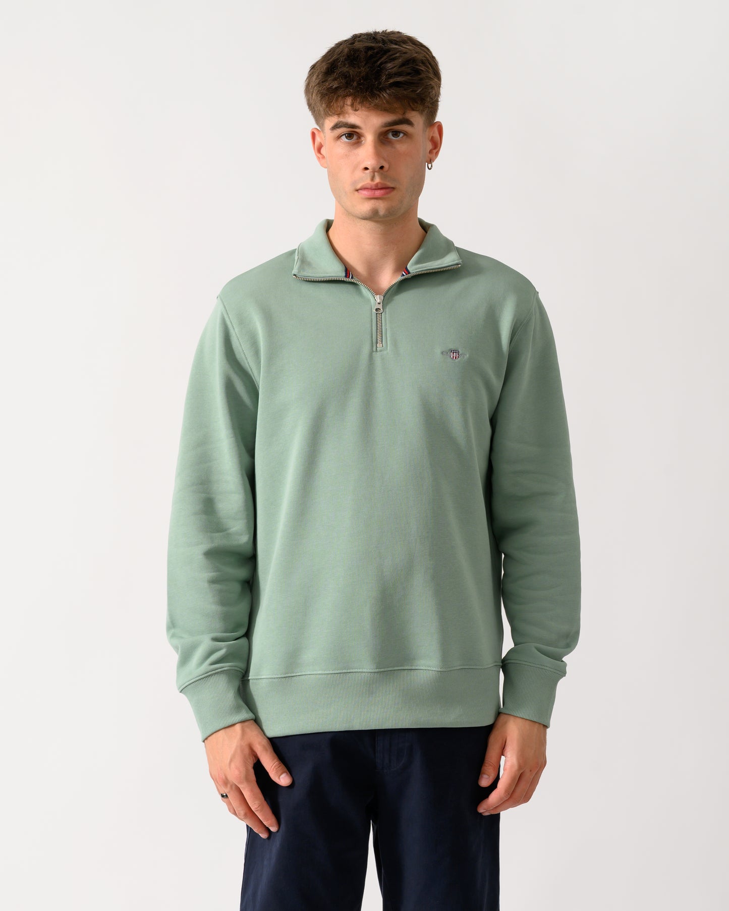 model wearing a GANT Mens Regular Fit Shield Logo Half Zip Sweatshirt in 308 Surplus Mint