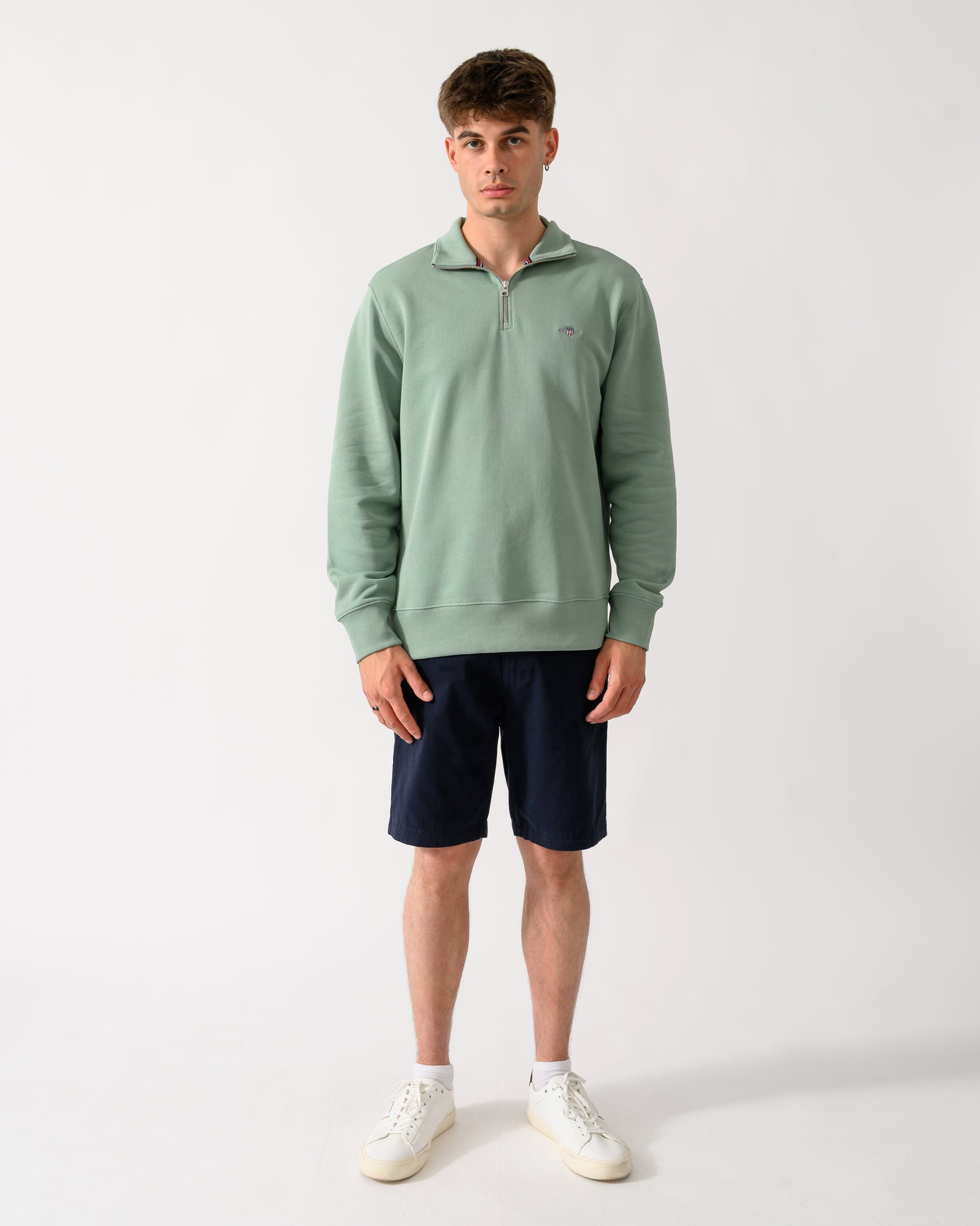 full length shot of a model wearing a GANT Mens Regular Fit Shield Logo Half Zip Sweatshirt in 308 Surplus Mint