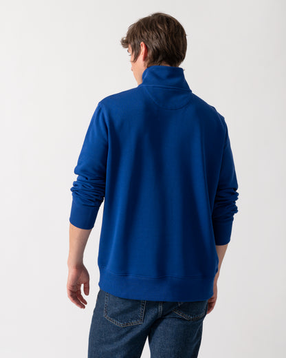back of model wearing a GANT Mens Regular Fit Shield Logo Half Zip Sweatshirt in 435 Crisp Blue