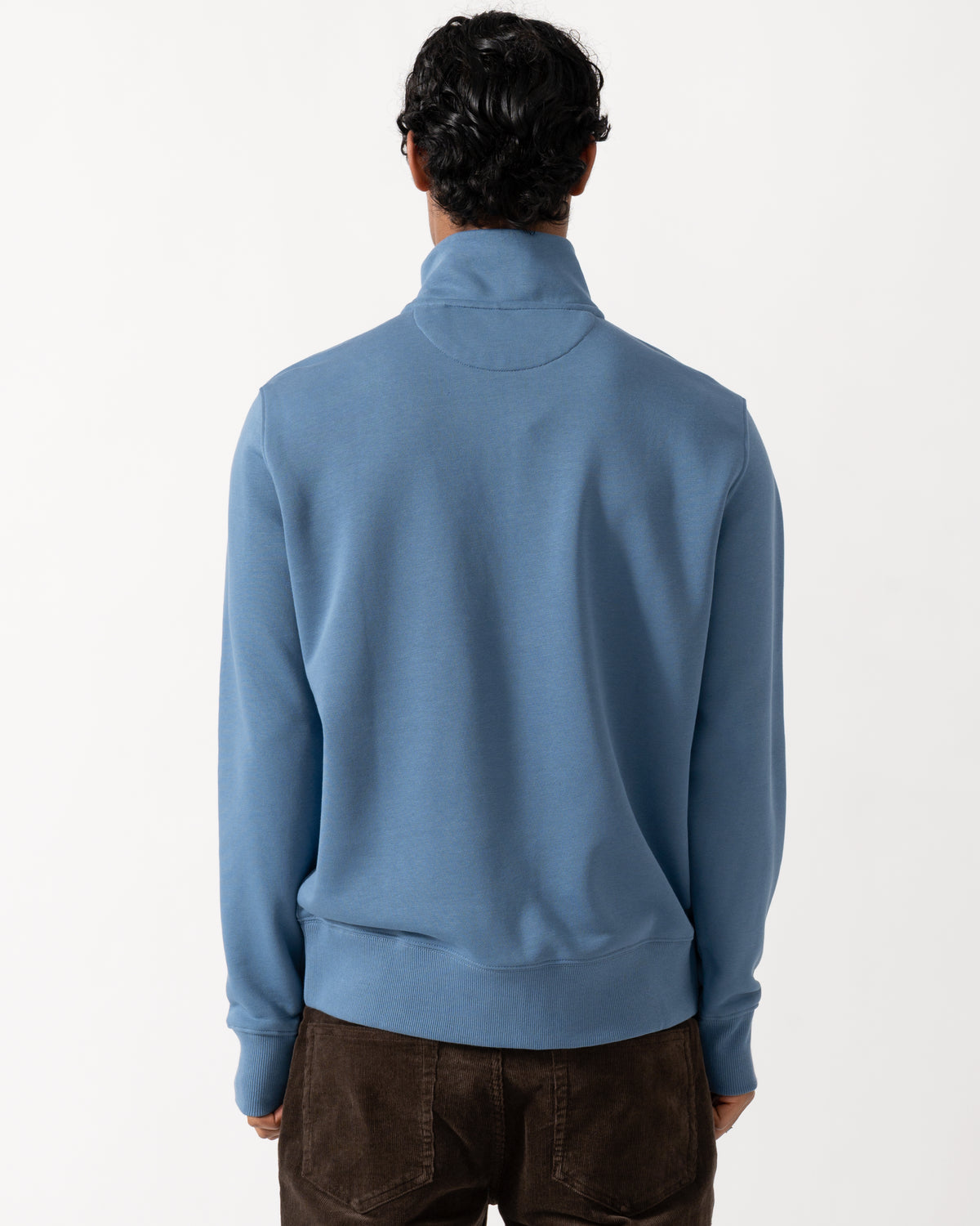 Studio photograph showing the back of a model wearing a GANT Mens Regular Fit Shield Logo Half Zip Sweatshirt in 476 Blue Horizon