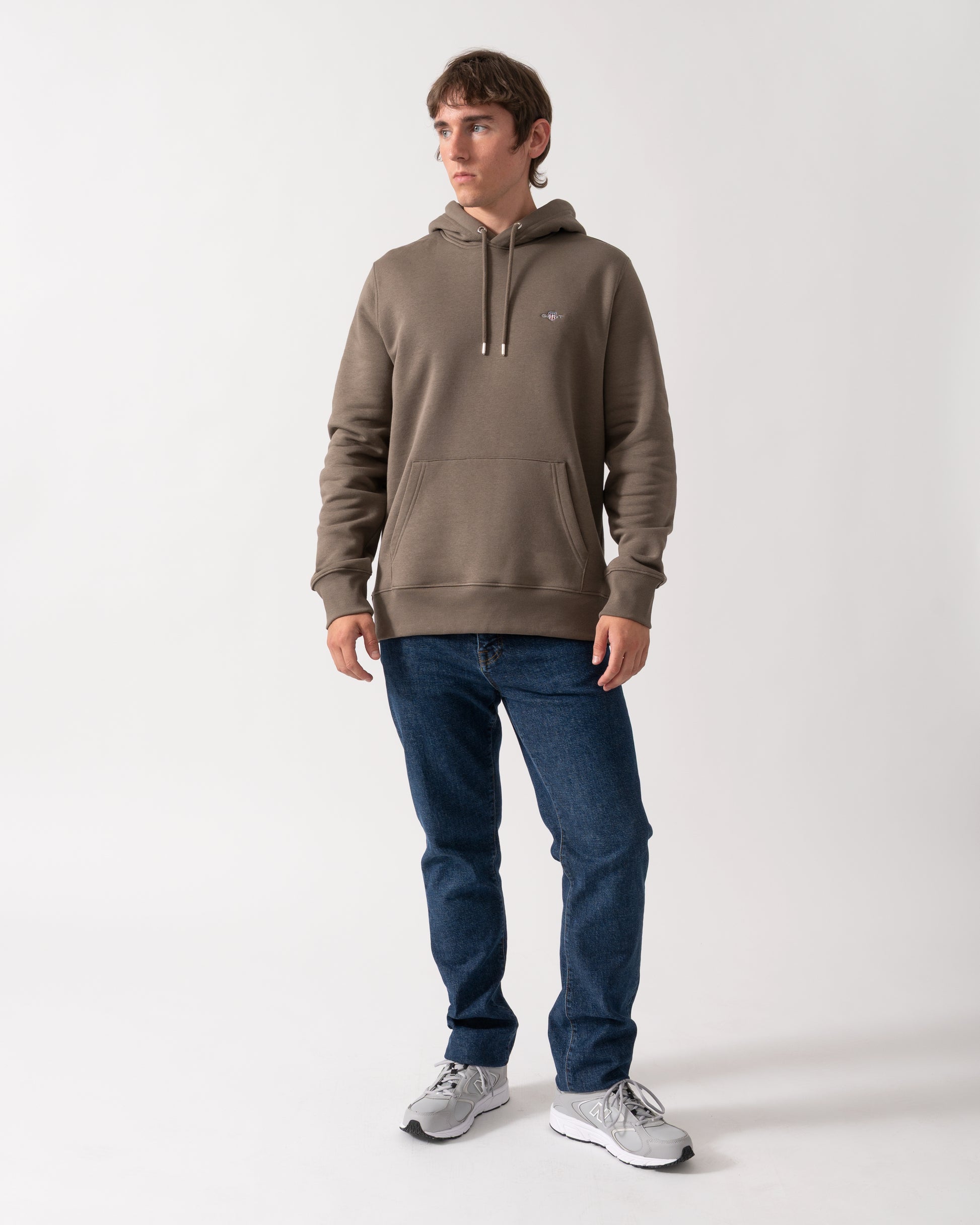full length of model wearing a GANT Mens Regular Fit Shield Logo Pullover Hoodie in 260 Faded Taupe
