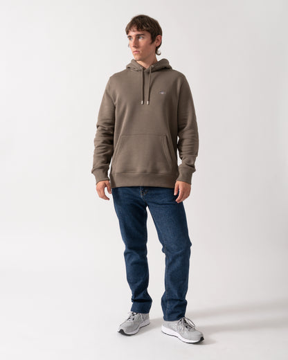 full length of model wearing a GANT Mens Regular Fit Shield Logo Pullover Hoodie in 260 Faded Taupe