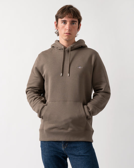 model wearing a GANT Mens Regular Fit Shield Logo Pullover Hoodie in 260 Faded Taupe