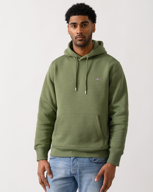 model wearing a GANT Mens Regular Fit Shield Logo Pullover Hoodie in 379 Dry Herb Green