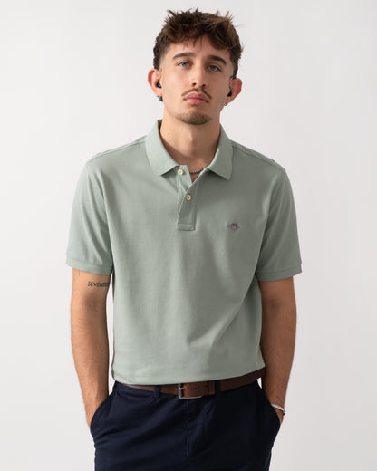 Model wearing a GANT Mens Regular Fit Short Sleeve Shield Logo Pique Polo in Ceramic Grey