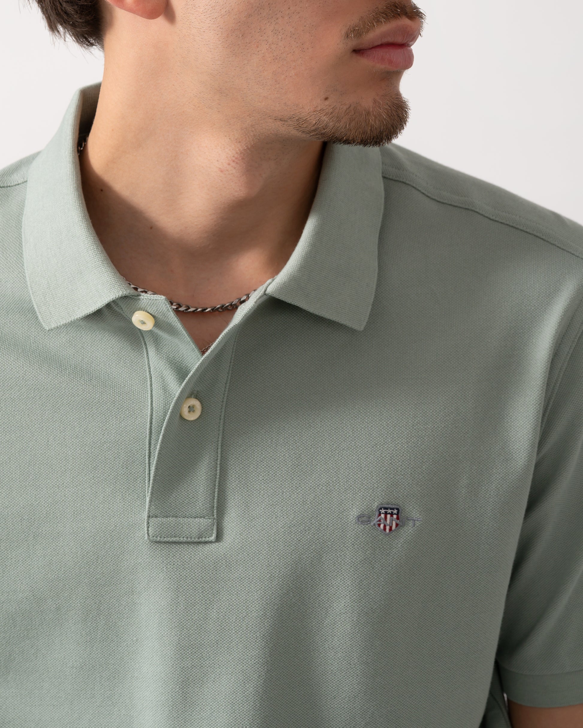 Close up of a Model wearing a GANT Mens Regular Fit Short Sleeve Shield Logo Pique Polo in Ceramic Grey