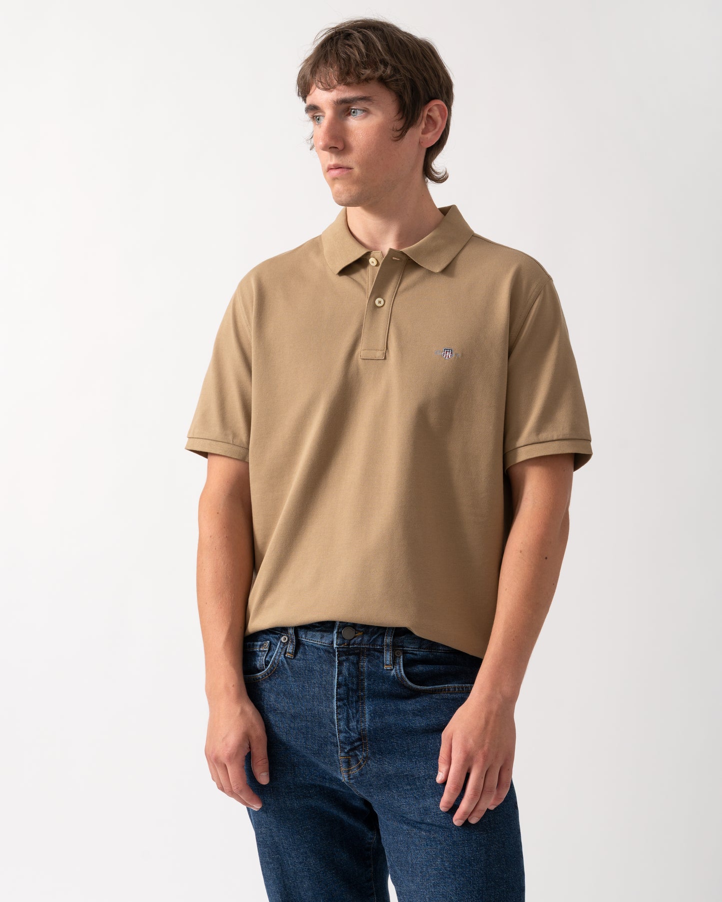 model wearing a GANT Mens Regular Fit Short Sleeve Shield Logo Pique Polo - 264 Light Taupe