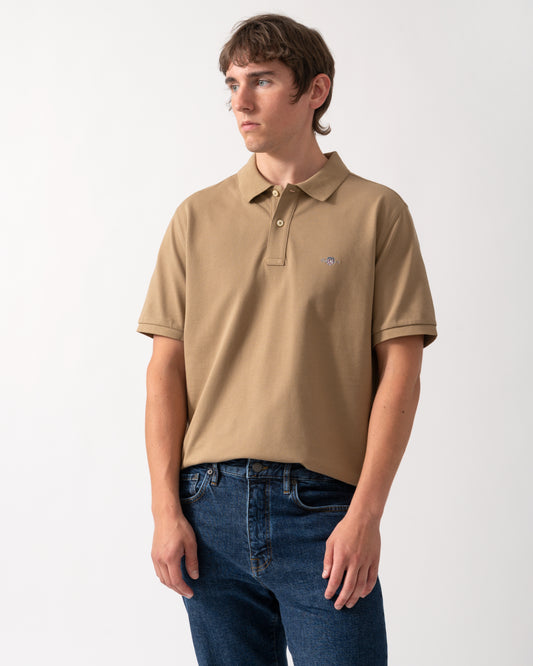 model wearing a GANT Mens Regular Fit Short Sleeve Shield Logo Pique Polo - 264 Light Taupe