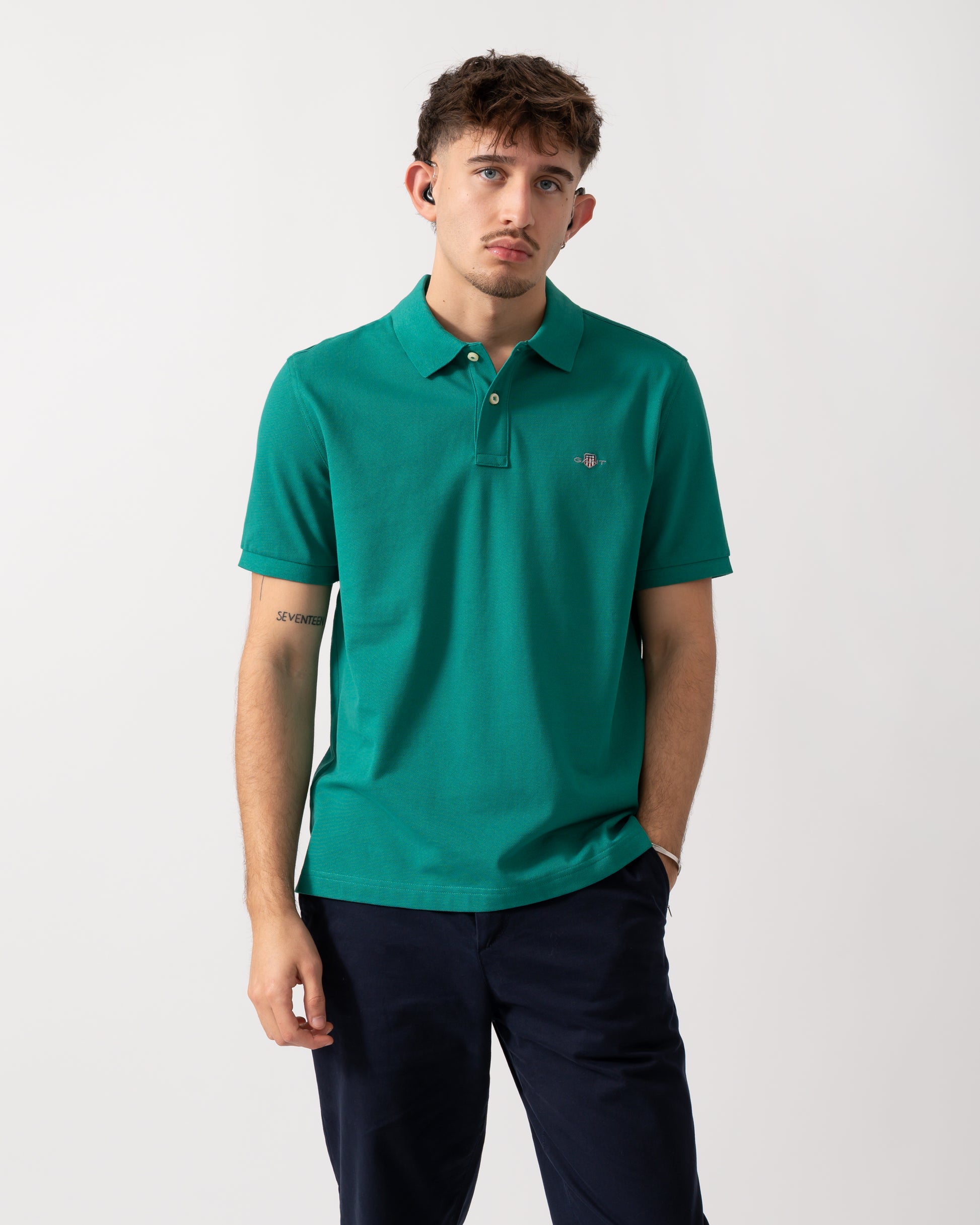 Model wearing a GANT Mens Regular Fit Short Sleeve Shield Logo Pique Polo in Botanical Hue