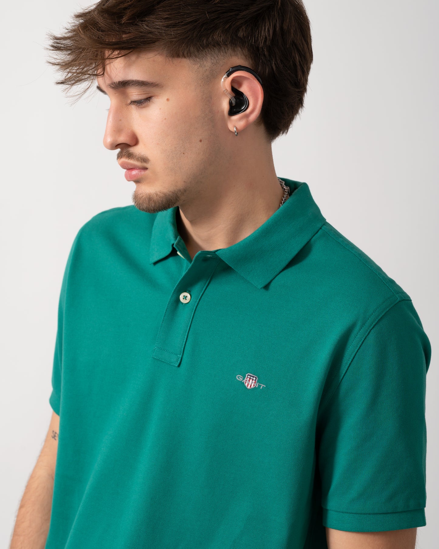 detail shot of a Model wearing a GANT Mens Regular Fit Short Sleeve Shield Logo Pique Polo in Botanical Hue