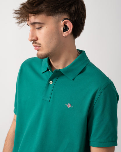 detail shot of a Model wearing a GANT Mens Regular Fit Short Sleeve Shield Logo Pique Polo in Botanical Hue