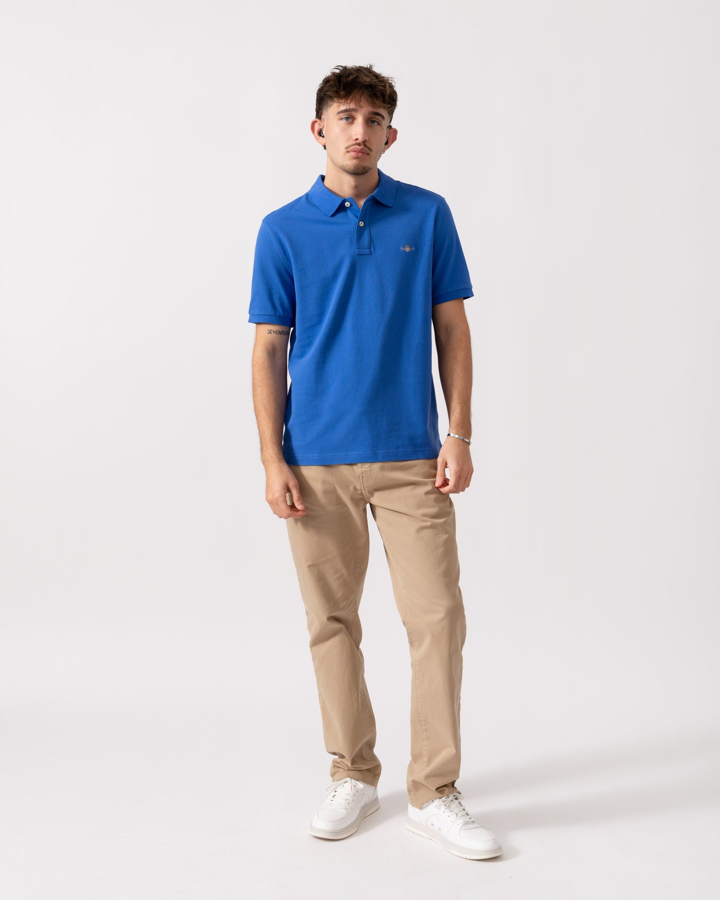 full length of Model wearing a GANT Mens Regular Fit Short Sleeve Shield Logo Pique Polo in Royal Blue