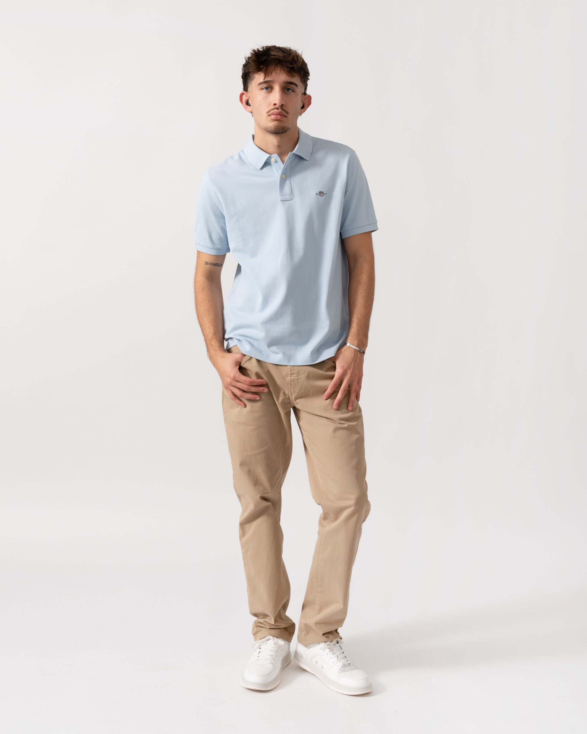 full length shot of a model wearing a GANT Mens Regular Fit Short Sleeve Shield Logo Pique Polo in Fresh Blue