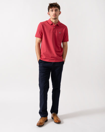 Lull length shot of a Model wearing a GANT Mens Regular Fit Short Sleeve Shield Logo Pique Polo in Muted Red
