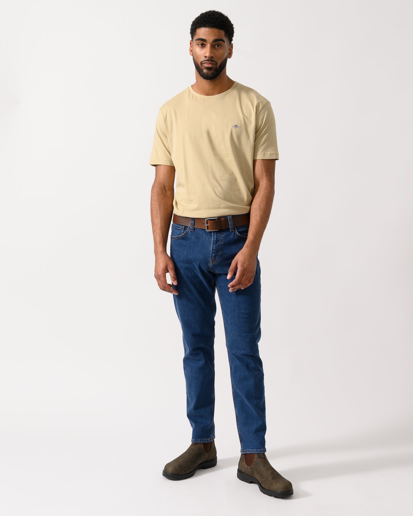 full length shot of a model wearing a GANT Mens Regular Fit Short Sleeve Shield Logo T-Shirt in Oat Beige