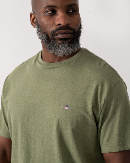 detail shot a a model wearing a GANT Mens Regular Fit Short Sleeve Shield Logo T-Shirt in Dark Cactus Melange