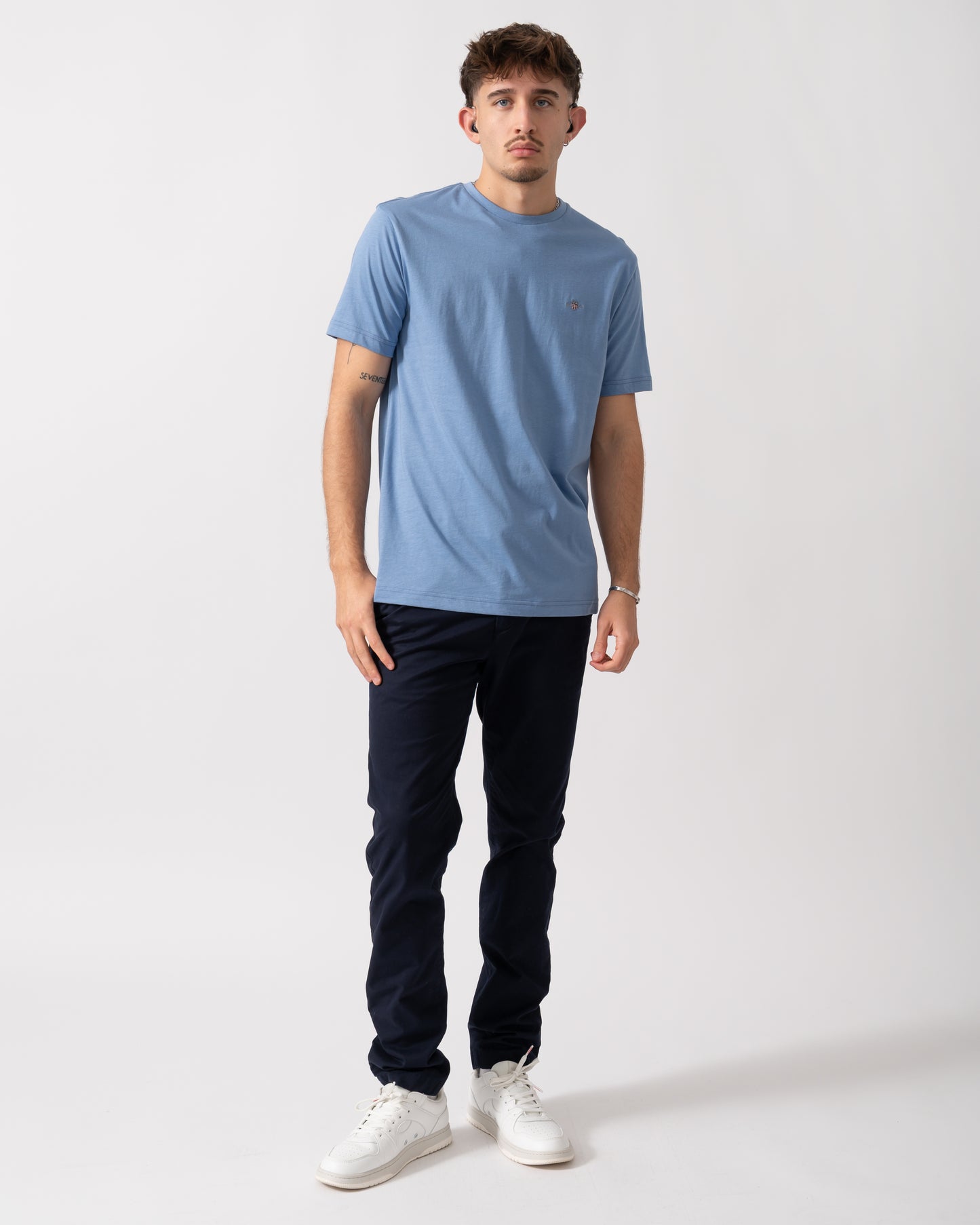 full length of a Model wearing a GANT Mens Regular Fit Short Sleeve Shield Logo T-Shirt in Faded Denim