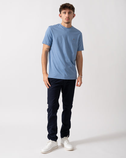 full length of a Model wearing a GANT Mens Regular Fit Short Sleeve Shield Logo T-Shirt in Faded Denim