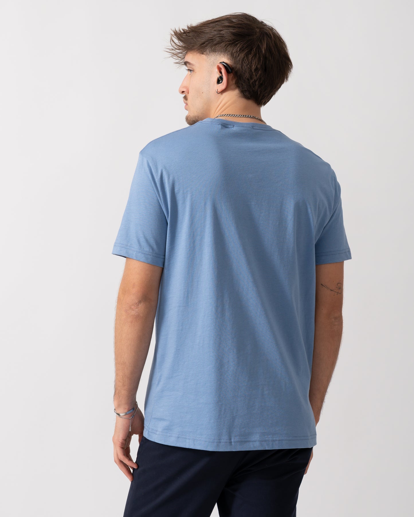 back detail of a Model wearing a GANT Mens Regular Fit Short Sleeve Shield Logo T-Shirt in Faded Denim