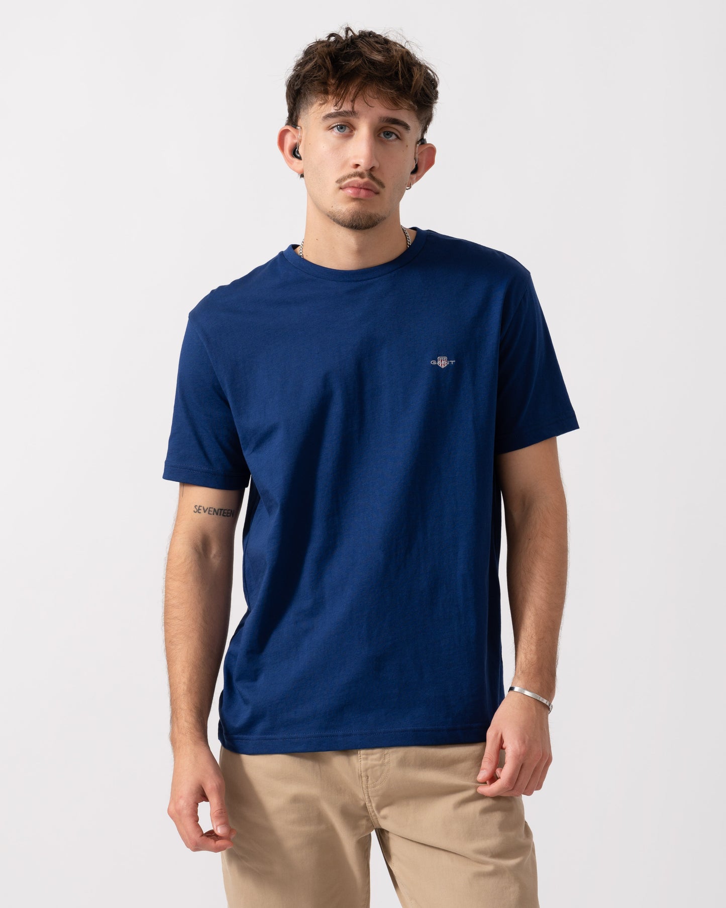 model wearing a GANT Mens Regular Fit Short Sleeve Shield Logo T-Shirt in Rich Navy