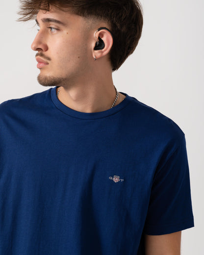 detail shot of a model wearing a GANT Mens Regular Fit Short Sleeve Shield Logo T-Shirt in Rich Navy