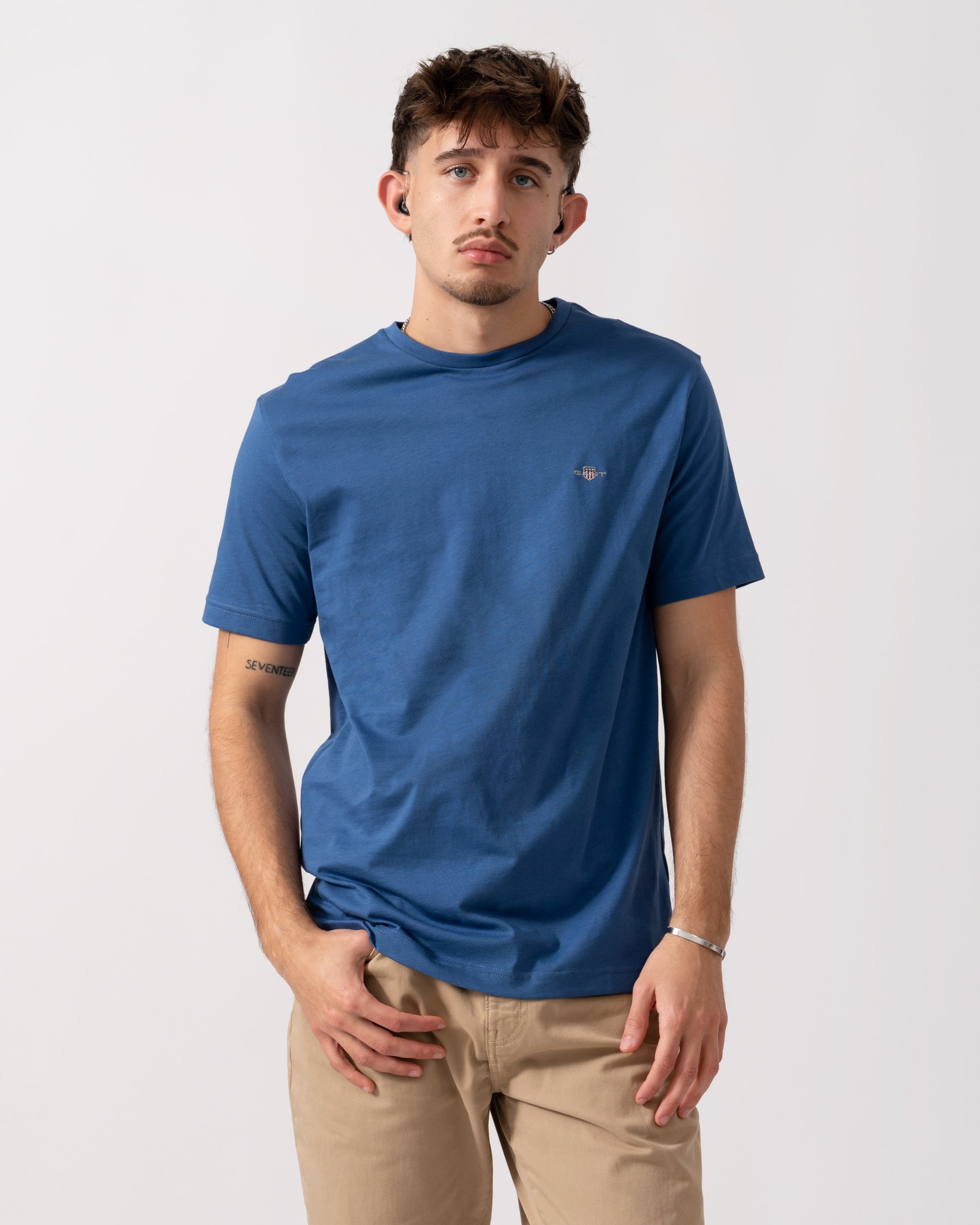 Model wearing a GANT Mens Regular Fit Short Sleeve Shield Logo T-Shirt in Vintage Blue