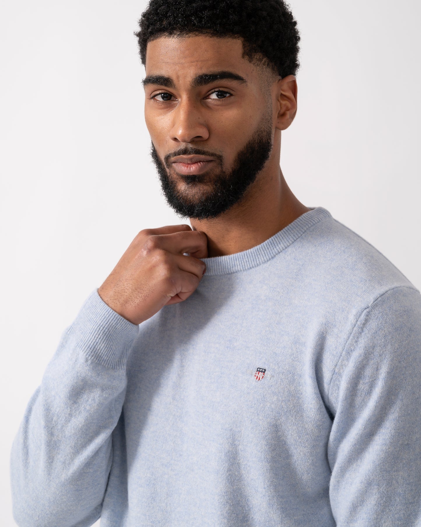 Close up of a model wearing a GANT Mens Superfine Lambswool Crew Neck Jumper in Ice Blue Melange