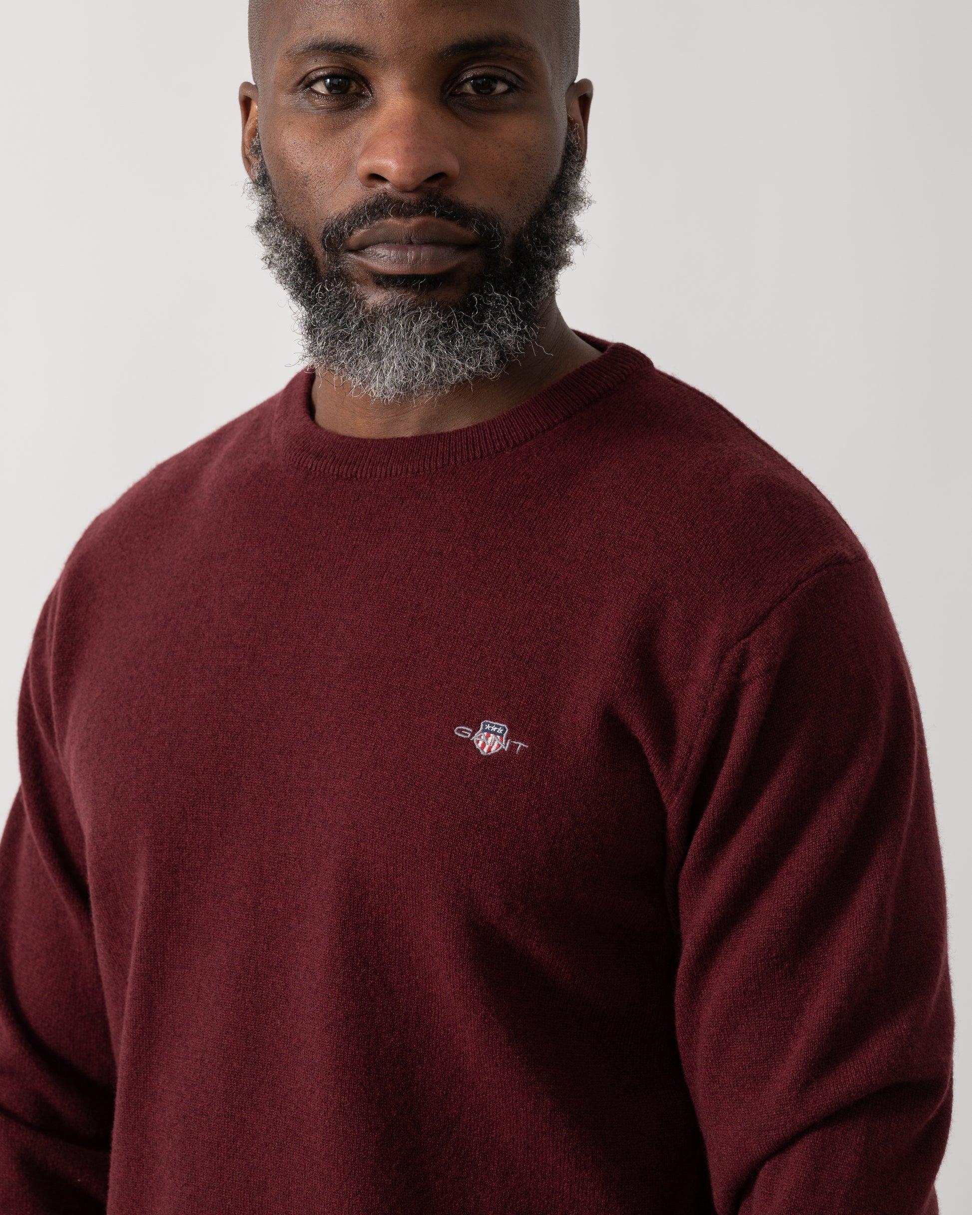 detail shot of a Model wearing a GANT Mens Superfine Lambswool Crew Neck Jumper in Bordeaux Melange