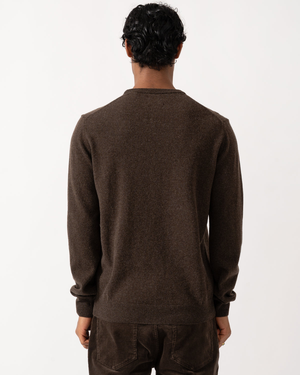 Studio photographshow the back of a model wearing a GANT Mens Superfine Lambswool Crew Neck Sweater in 280 Dark Brown Melange