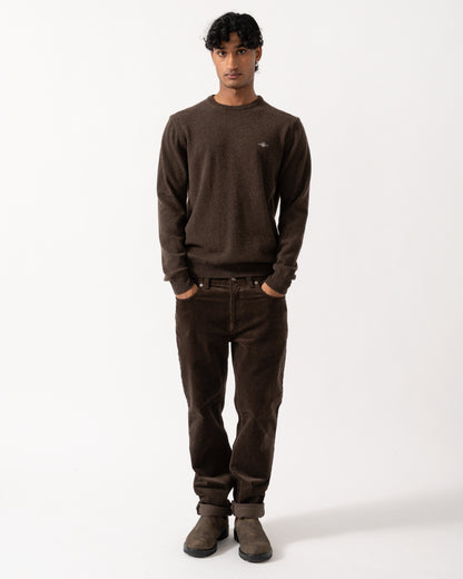 full length Studio photograph of a model wearing a GANT Mens Superfine Lambswool Crew Neck Sweater in 280 Dark Brown Melange