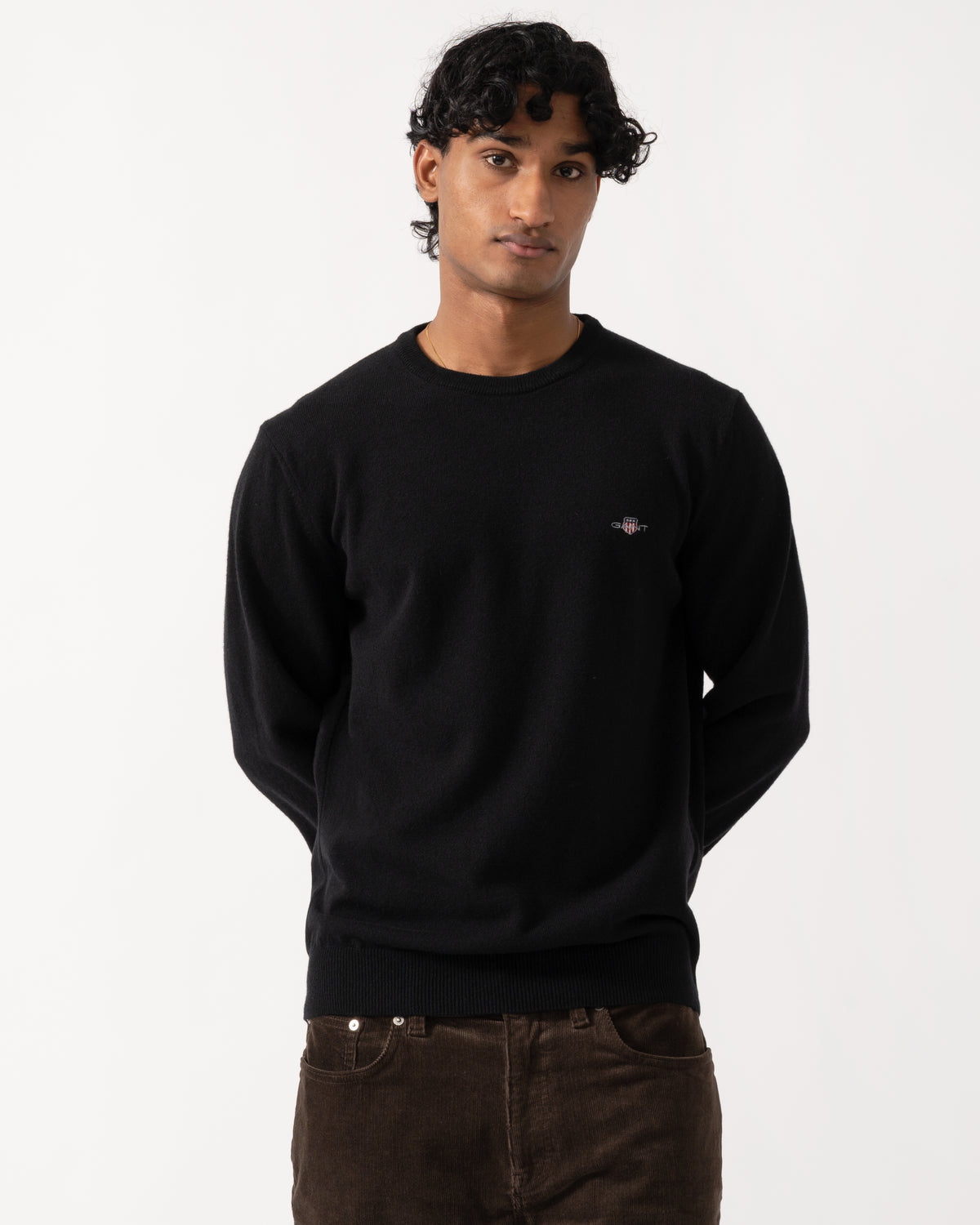 Studio photograph of a model wearing a GANT Mens Superfine Lambswool Crew Neck Sweater in 5 Black