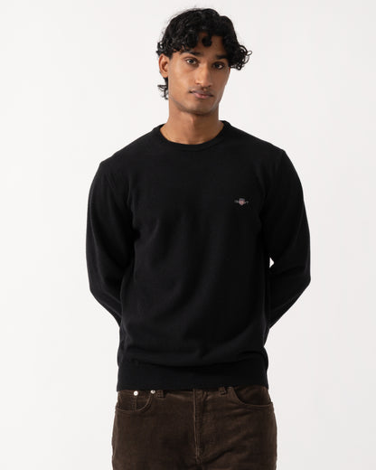 Studio photograph of a model wearing a GANT Mens Superfine Lambswool Crew Neck Sweater in 5 Black