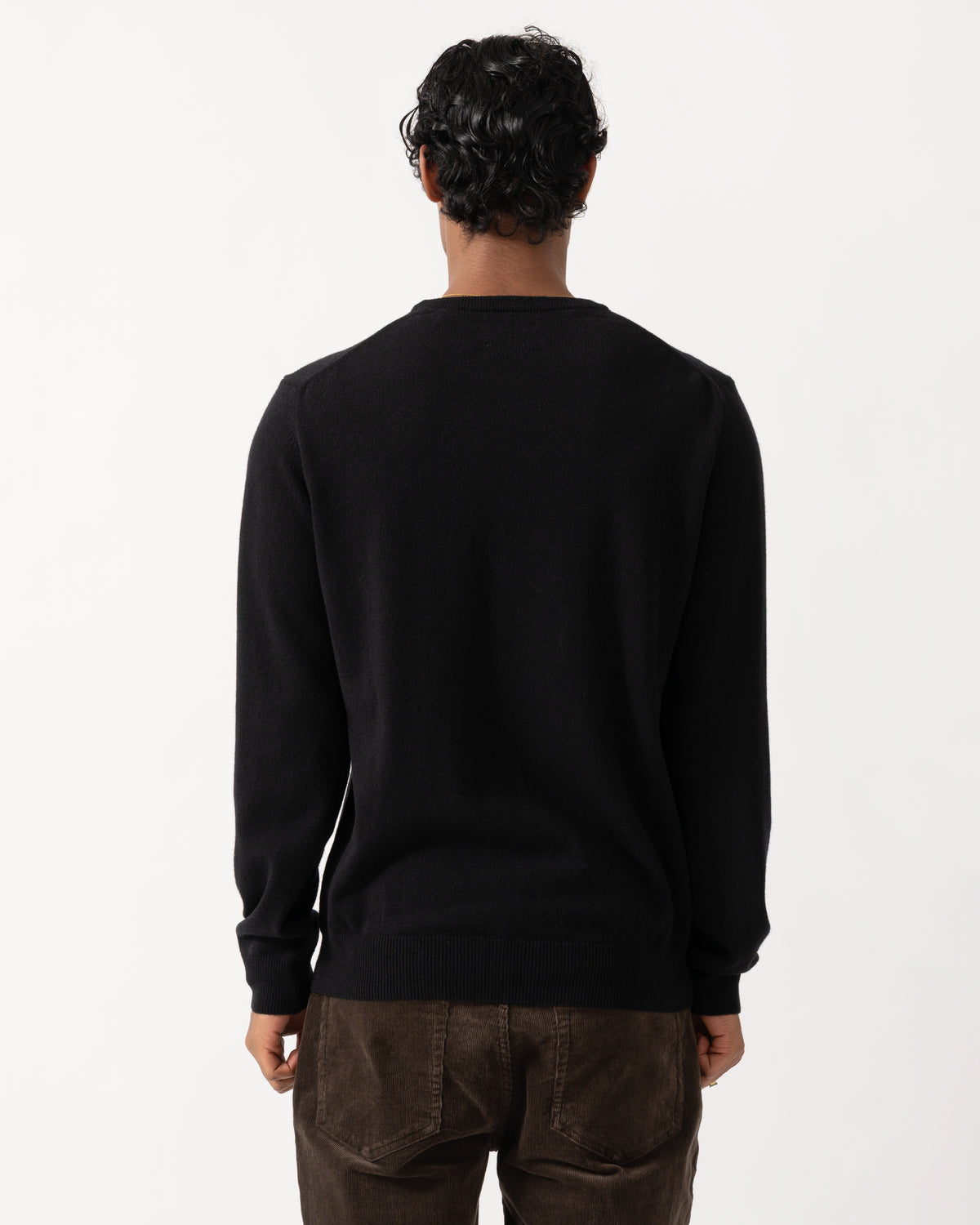 Studio photograph showing the back of a model wearing a GANT Mens Superfine Lambswool Crew Neck Sweater in 5 Black