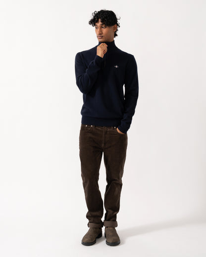 full length studio photograph showing a model wearing a GANT Mens Superfine Lambswool Half Zip Sweater in 410 Marine