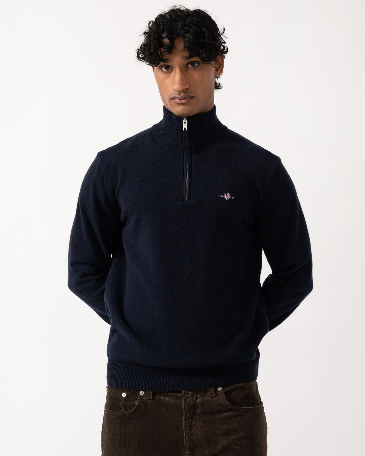 studio photograph showing a model wearing a GANT Mens Superfine Lambswool Half Zip Sweater in 410 Marine