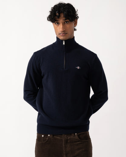 studio photograph showing a model wearing a GANT Mens Superfine Lambswool Half Zip Sweater in 410 Marine