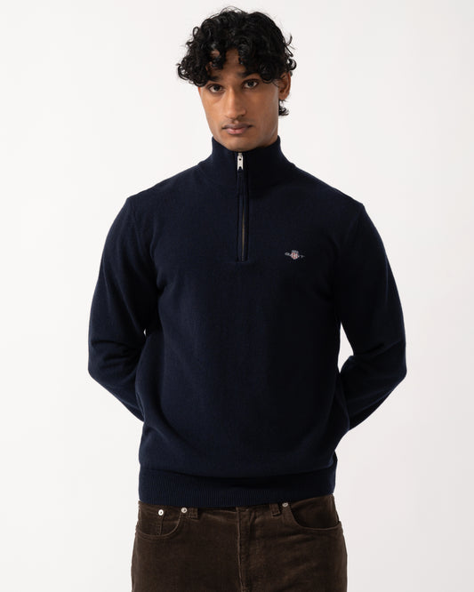 studio photograph showing a model wearing a GANT Mens Superfine Lambswool Half Zip Sweater in 410 Marine