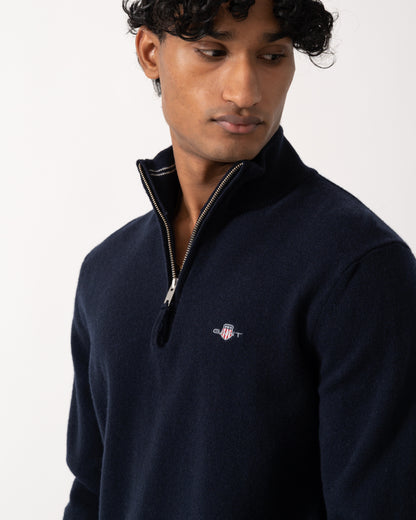 close up studio photograph showing a model wearing a GANT Mens Superfine Lambswool Half Zip Sweater in 410 Marine
