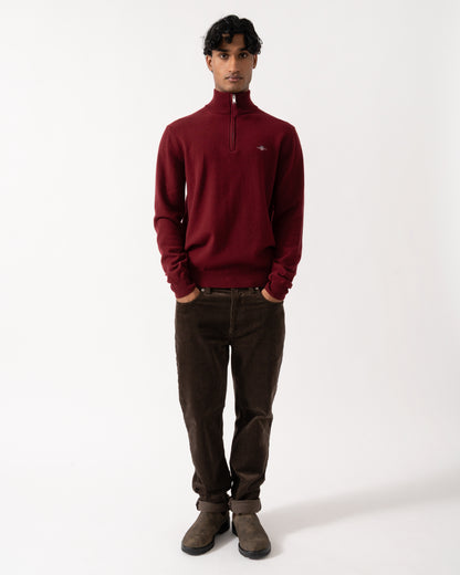 full length Studio photograph of a model wearing a GANT Mens Superfine Lambswool Half Zip Sweater in 604 Plumped Red