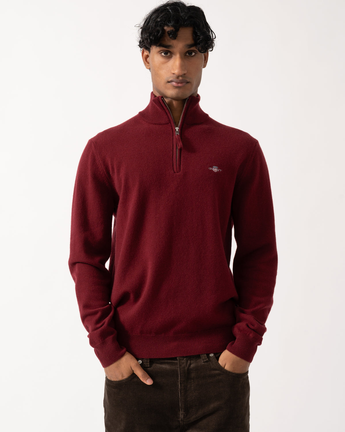 Studio photograph of a model wearing a GANT Mens Superfine Lambswool Half Zip Sweater in 604 Plumped Red
