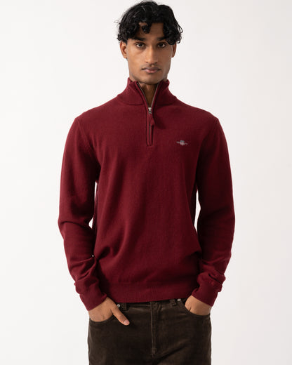 Studio photograph of a model wearing a GANT Mens Superfine Lambswool Half Zip Sweater in 604 Plumped Red