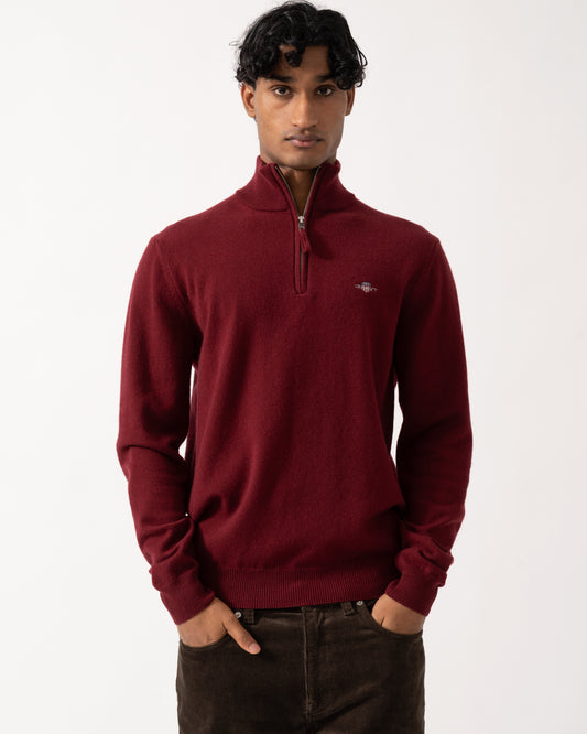 Studio photograph of a model wearing a GANT Mens Superfine Lambswool Half Zip Sweater in 604 Plumped Red
