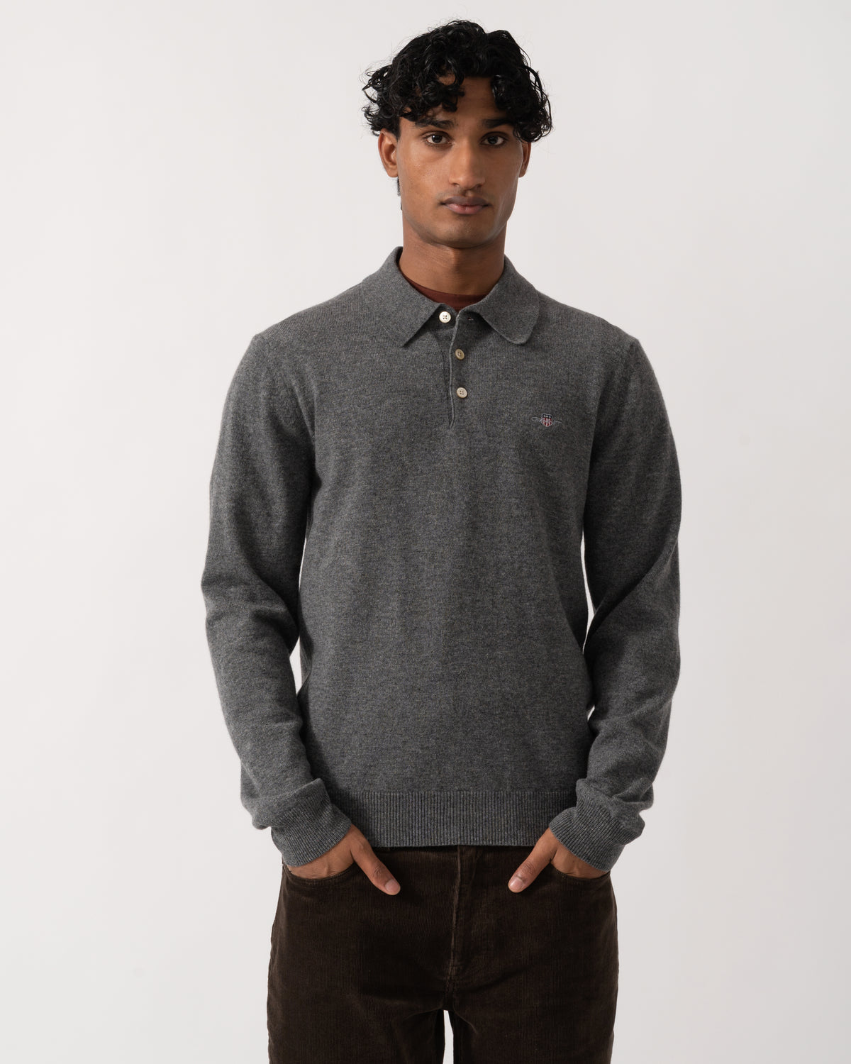 Studio photograph of a model wearing a GANT Mens Superfine Lambswool Long Sleeve Polo in 90 Charcoal Melange