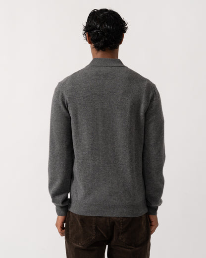 Studio photograph showing the back of a model wearing a GANT Mens Superfine Lambswool Long Sleeve Polo in 90 Charcoal Melange