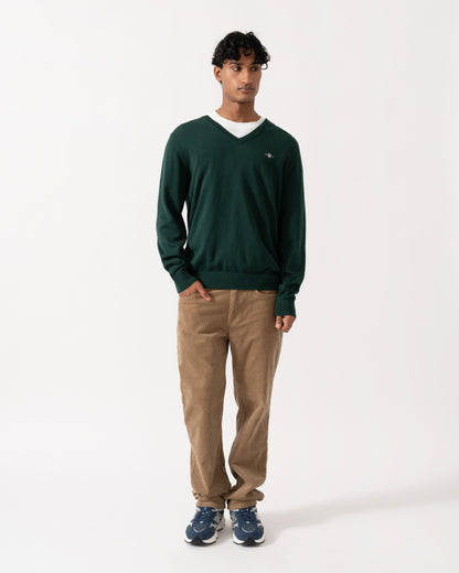 Model wearing the GANT Mens Classic Cotton Shield Logo V-Neck Jumper - 374 Tartan Green