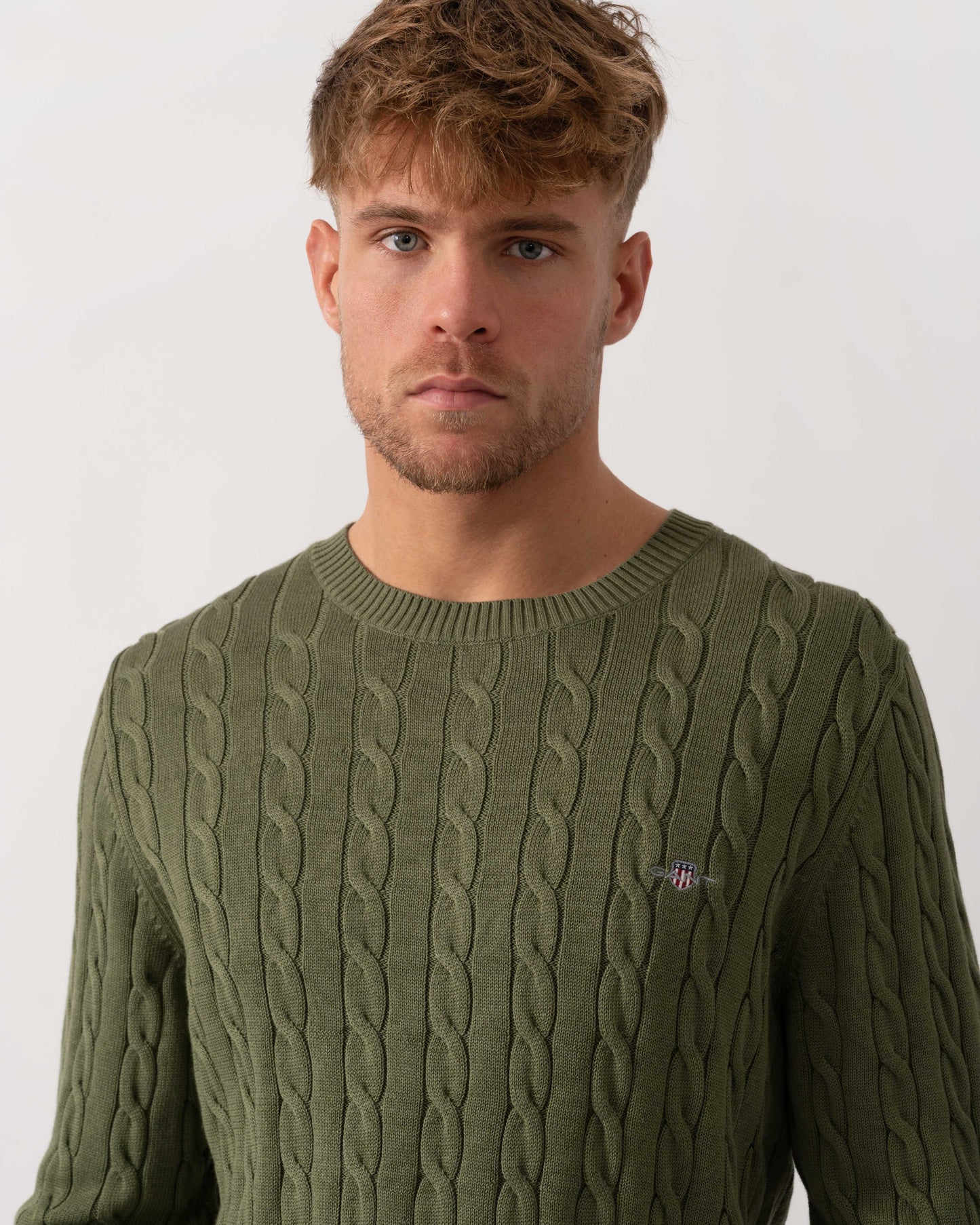 Model wearing GANT Mens Cotton Cable Knit Crew Neck Jumper in 379 Dry Herb Green - Neckline Detail